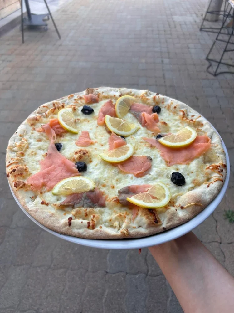 Pizza saumon citron sur assiette blanche