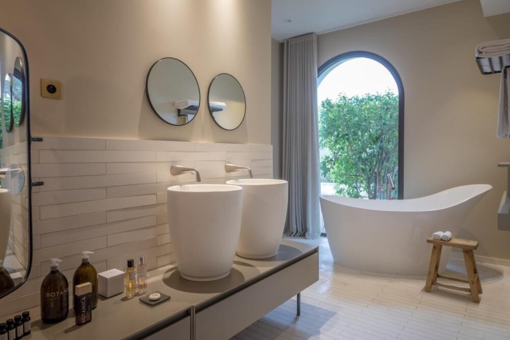 Salle de bain moderne avec baignoire et lavabos.