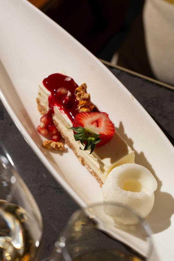 Dessert élégant avec fraises et sauce rouge.