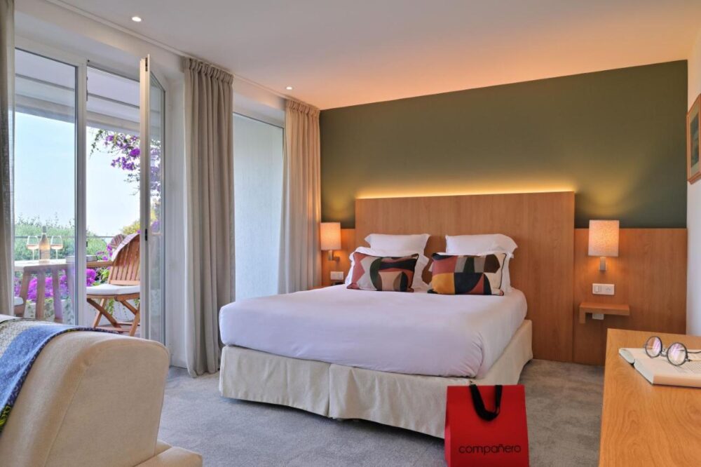 Chambre d'hôtel moderne avec balcon fleuri.