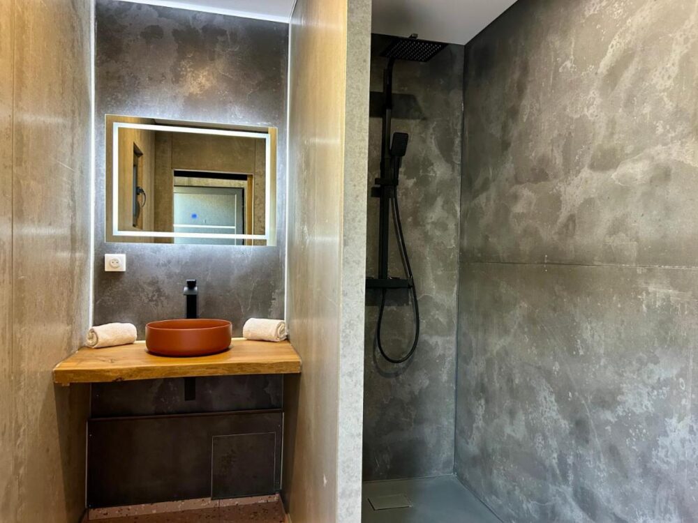 Salle de bain moderne avec lavabo et douche.