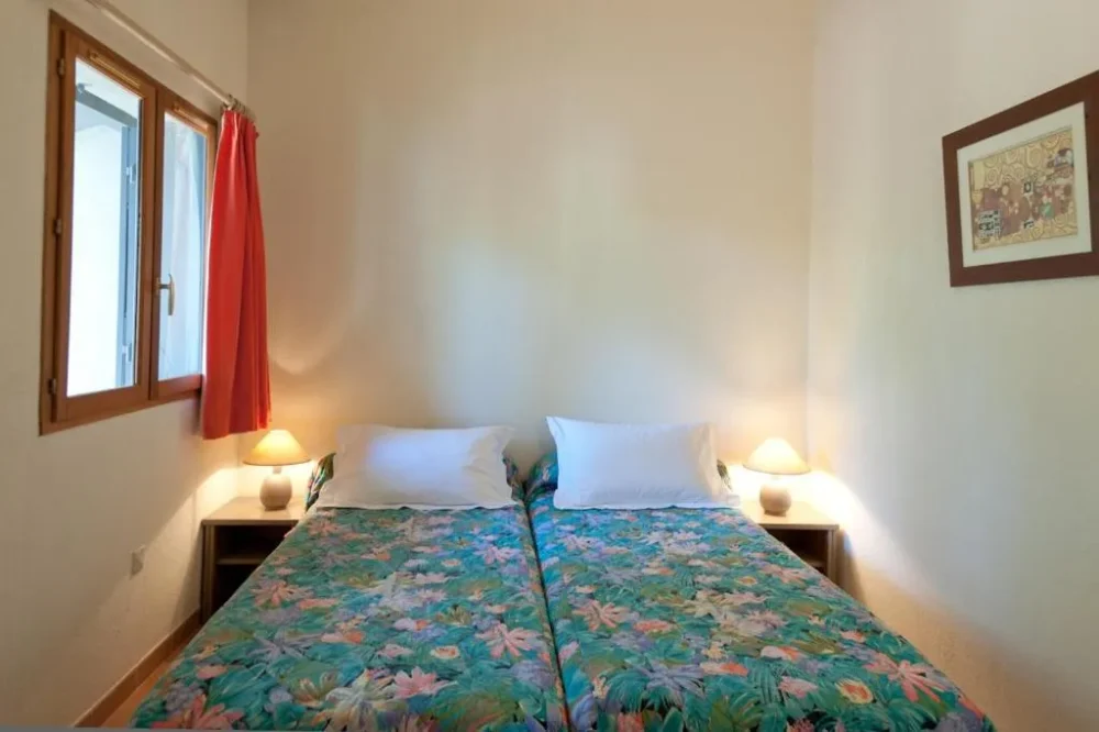 Chambre avec deux lits simples et décoration florale.