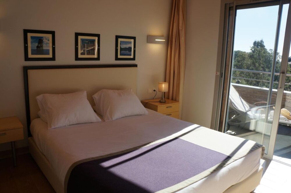 Chambre lumineuse avec lit double et terrasse.
