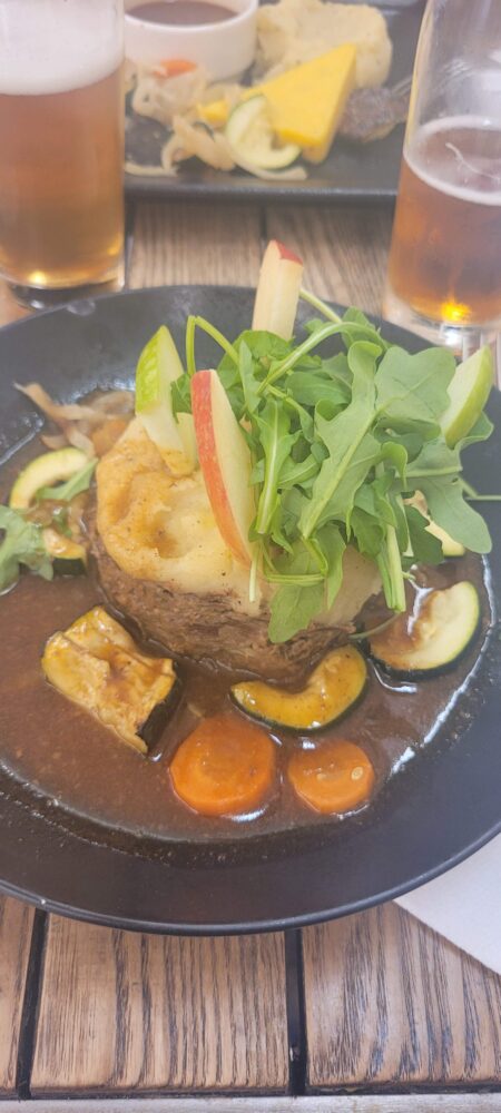 Plat avec viande, légumes et bière.