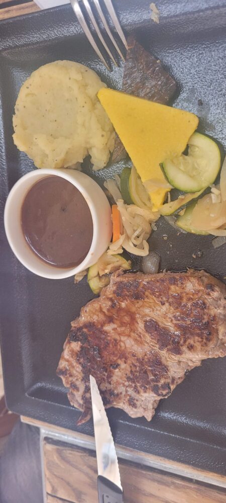 Assiette avec viande, légumes et sauce.