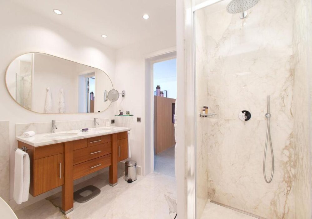 Salle de bain moderne avec douche et lavabo double.