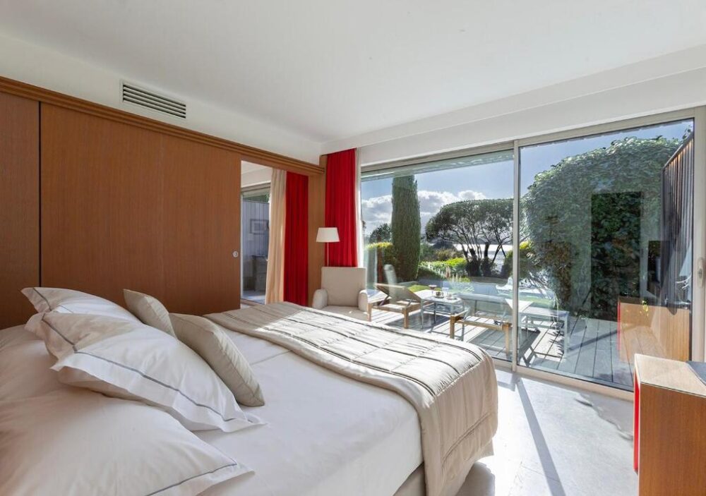 Chambre lumineuse avec vue sur jardin arboré.