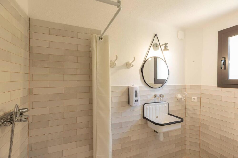 Salle de bain moderne avec douche et lavabo.