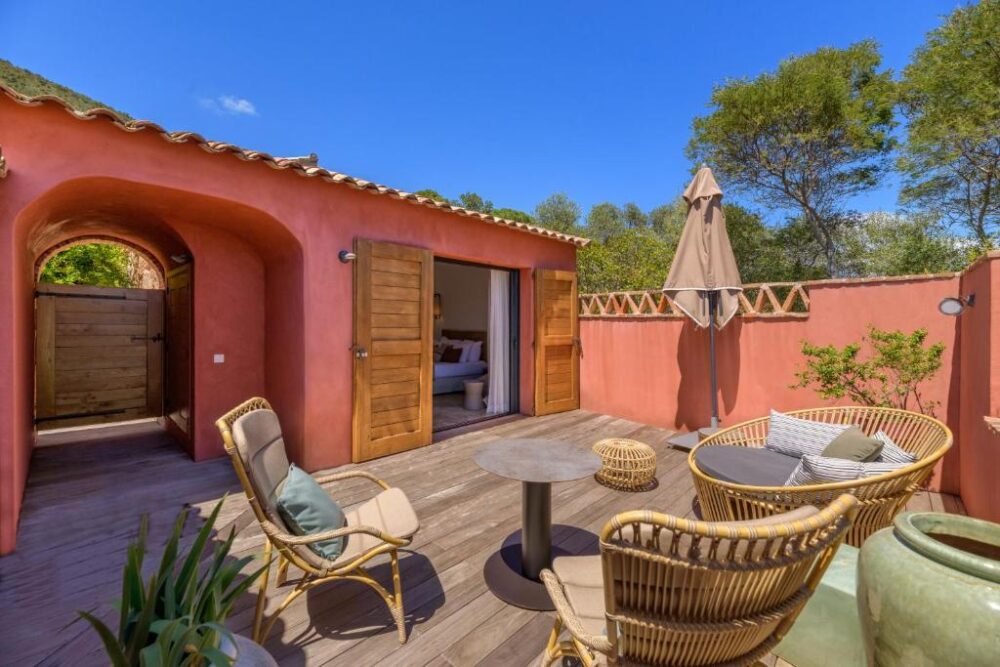 Terrasse ensoleillée avec mobilier en rotin.