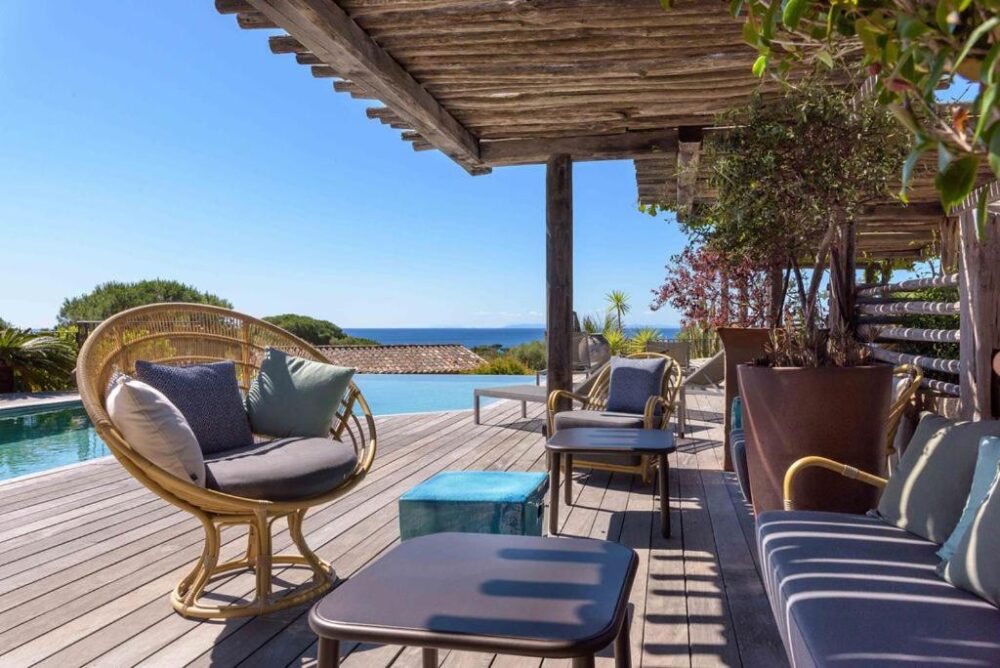Terrasse en bois avec piscine et vue mer.