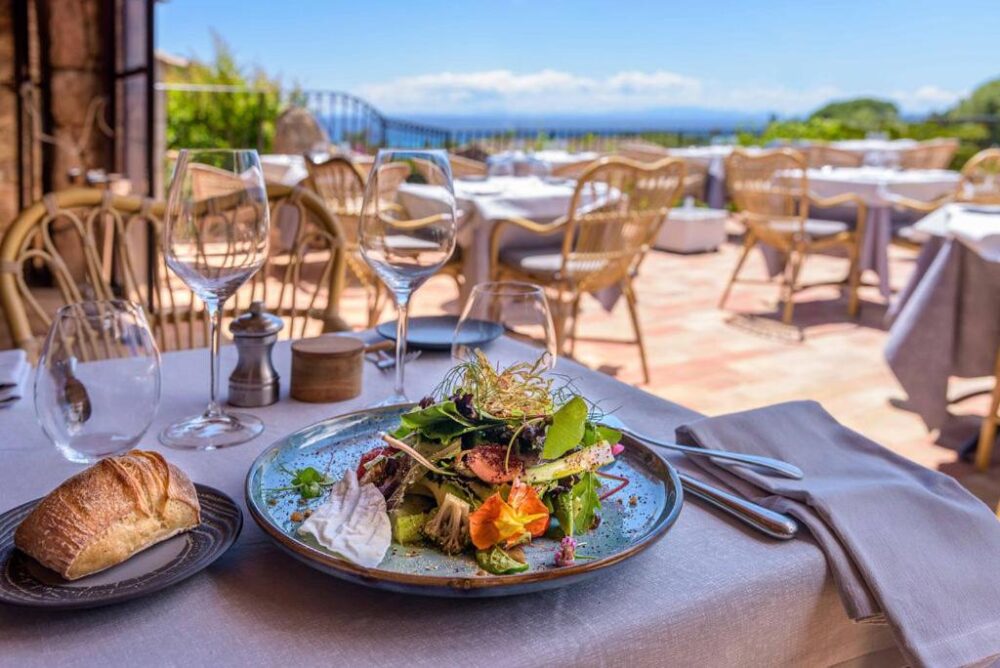 Table restaurant avec salade et vue terrasse.