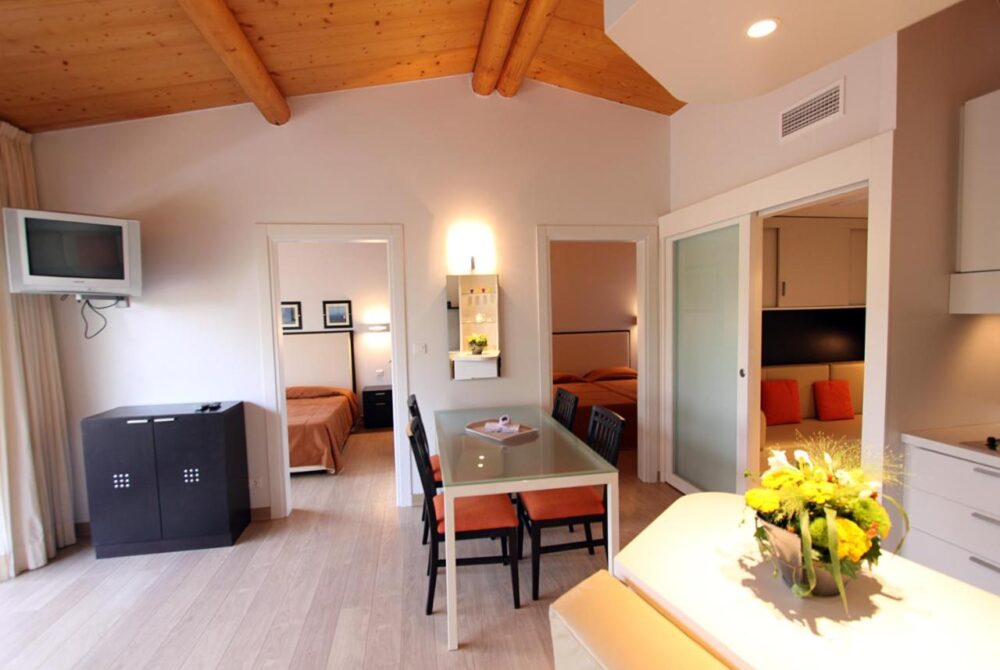 Salon moderne avec deux chambres et mobilier en bois.