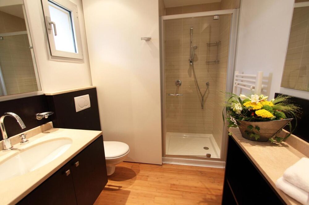 Salle de bain moderne avec douche et vasque.