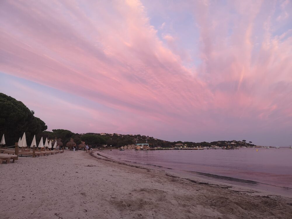 Plage au coucher de soleil aux nuances roses.