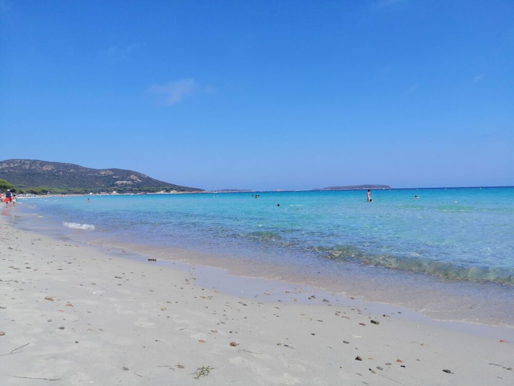 Plage de sable avec eau turquoise.