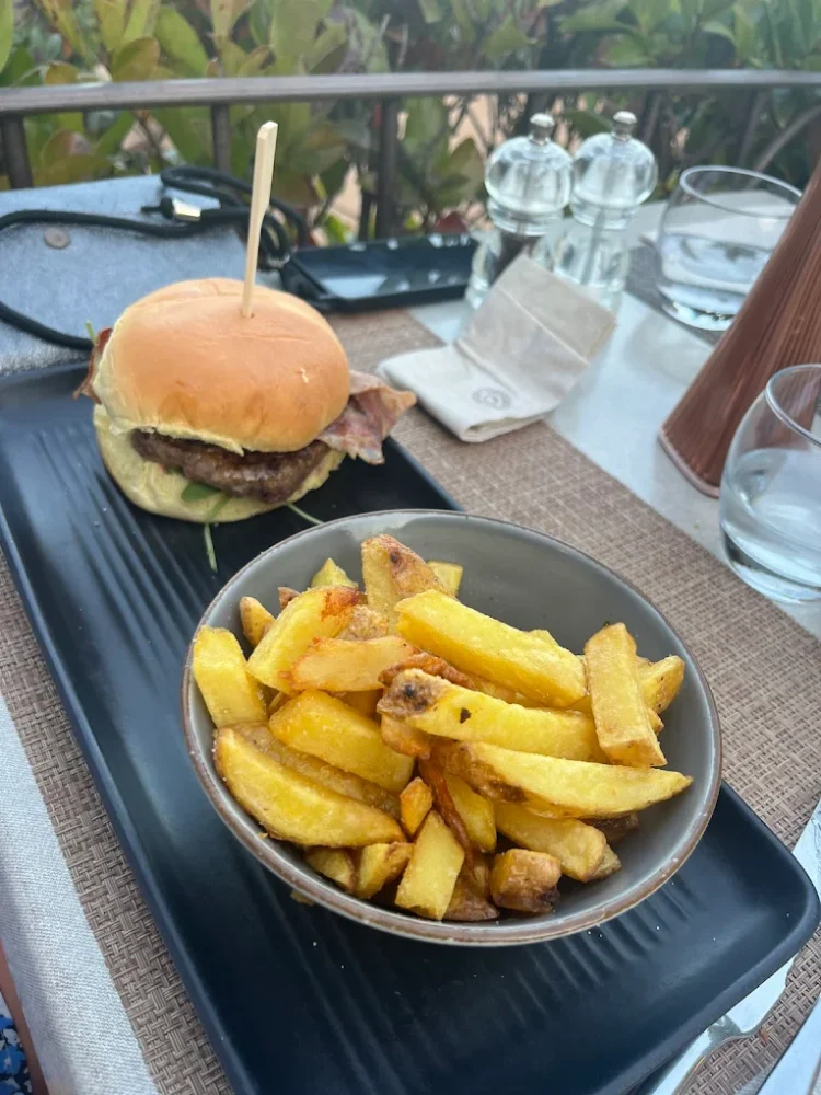 Burger et frites sur une assiette noire.