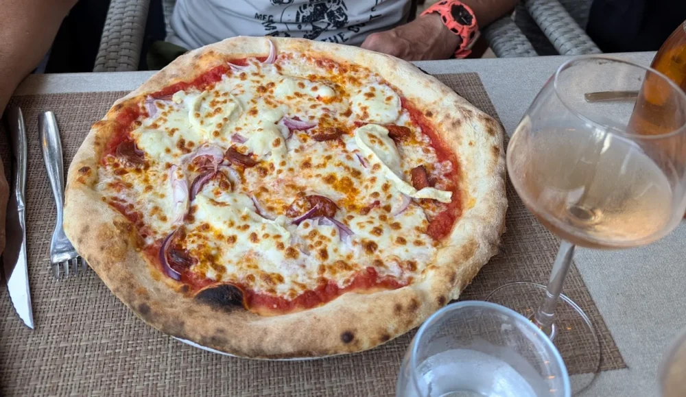 Pizza aux oignons et mozzarella sur table.