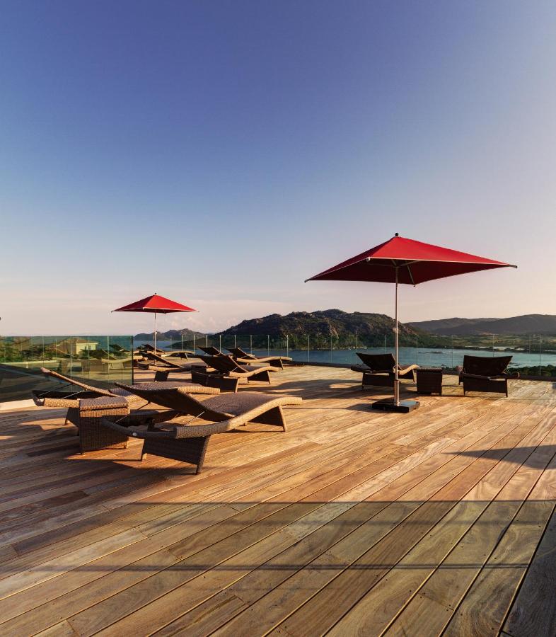 Terrasse avec chaises longues et parasols rouges.