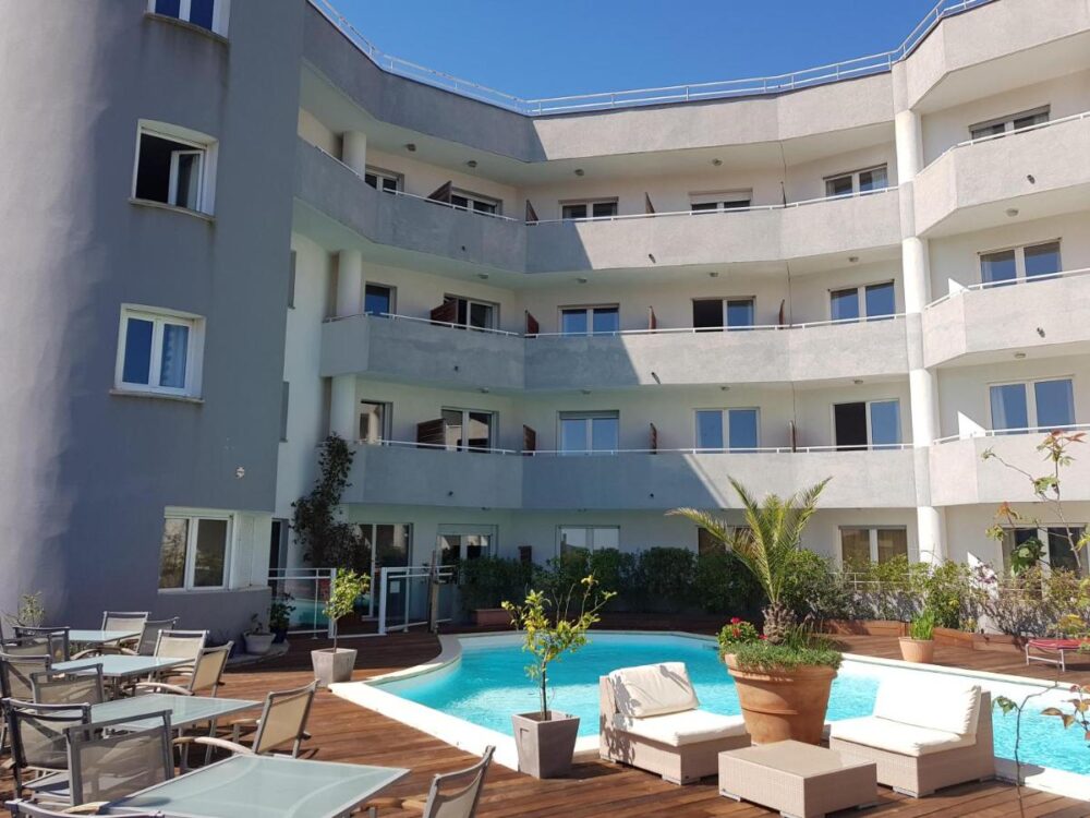 Hôtel moderne avec piscine extérieure et terrasse.
