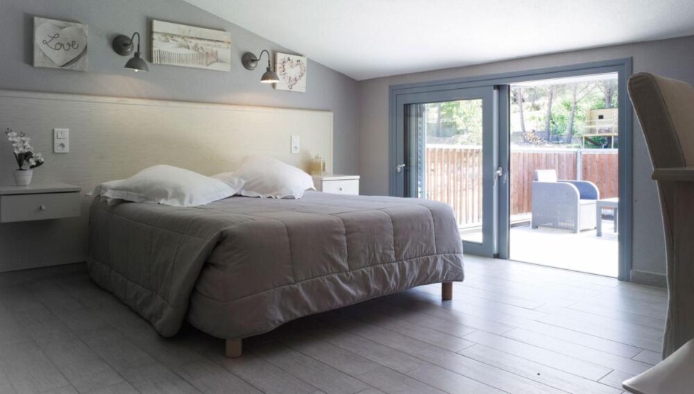 Chambre lumineuse avec lit double et terrasse.
