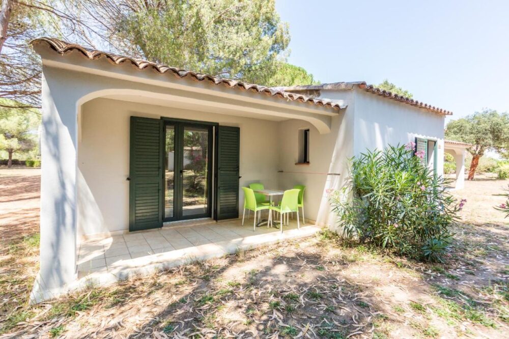 Petite maison avec terrasse et jardin.