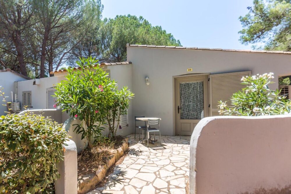 Entrée de bungalow avec jardin et meubles extérieurs.