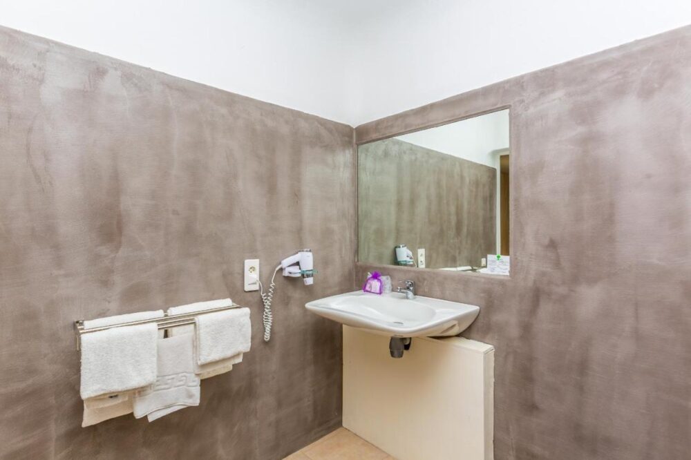 Salle de bain moderne avec miroir et lavabo.