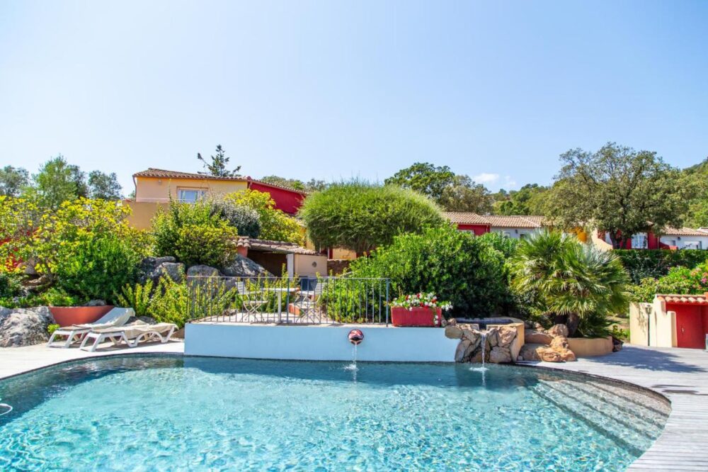 Maison avec piscine et jardin verdoyant.