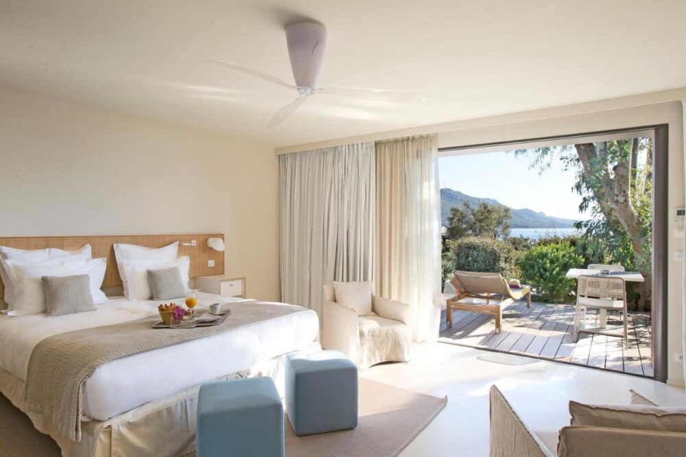 Chambre lumineuse avec terrasse et vue sur mer.