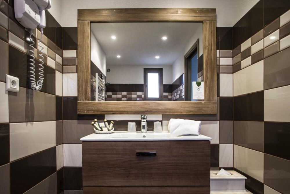 Salle de bain moderne avec miroir et lavabo.