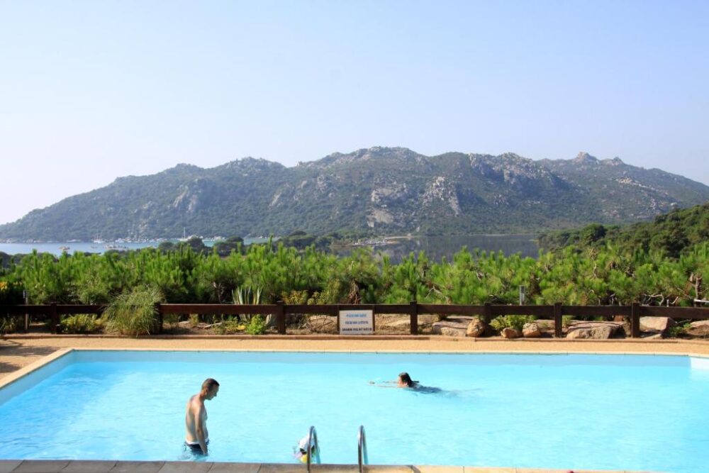 Piscine avec vue montagne, personne nageant.