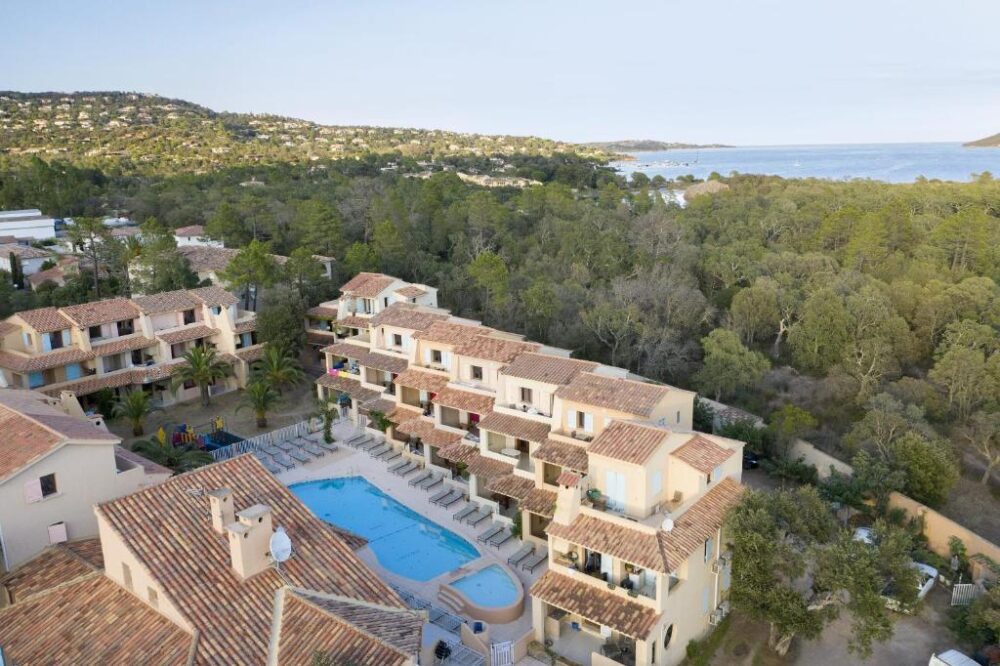 Complexe hôtelier avec piscine et vue sur la mer.
