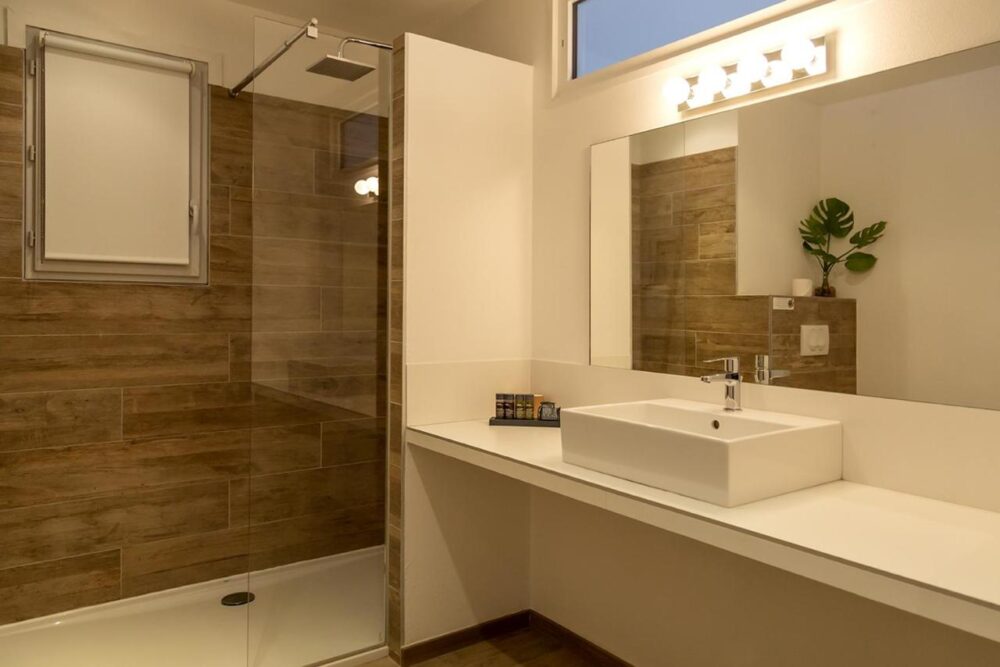 Salle de bain moderne avec douche et lavabo.