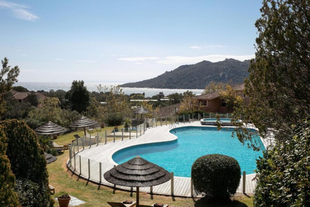 Piscine avec vue sur mer et montagnes.