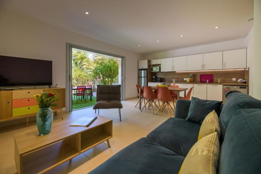 Salon moderne avec cuisine ouverte et terrasse.