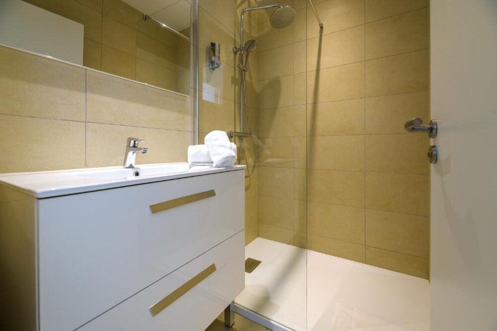 Salle de bain moderne avec douche et lavabo.