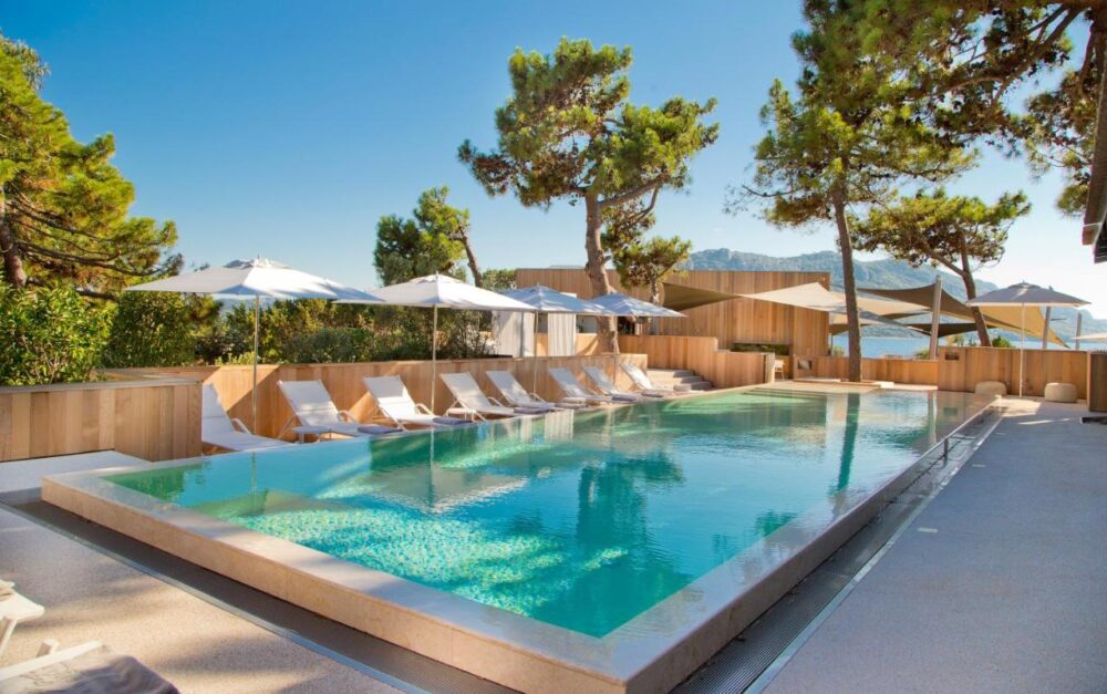 Piscine extérieure avec transats et parasols.