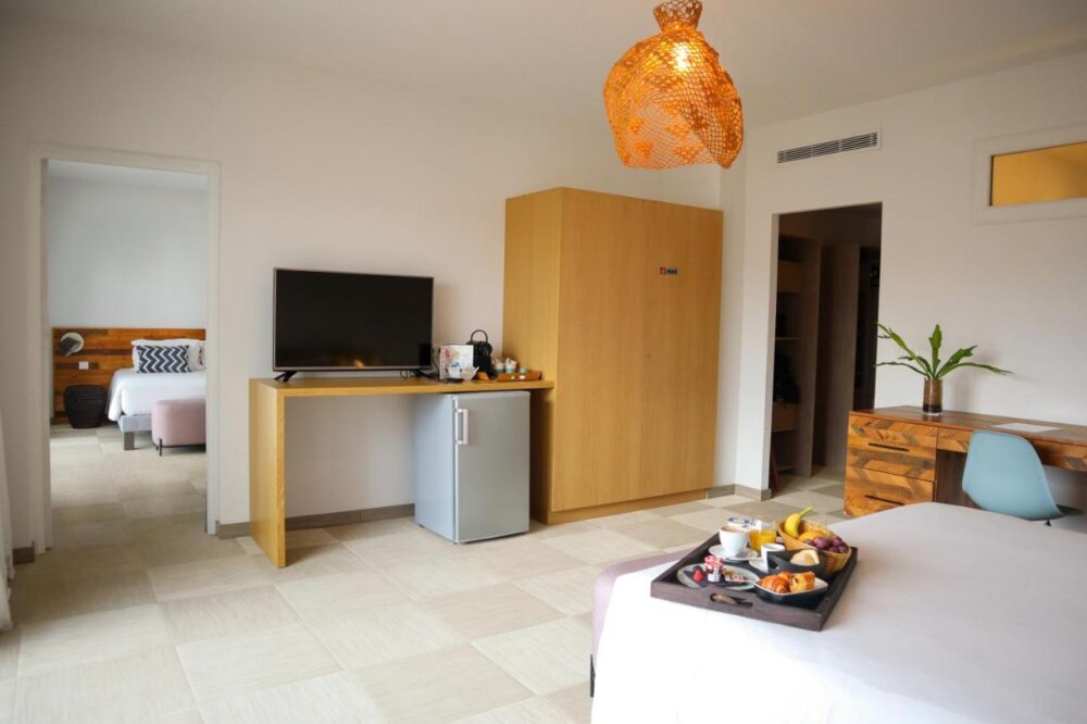 Chambre d'hôtel moderne avec plateau-repas sur le lit.