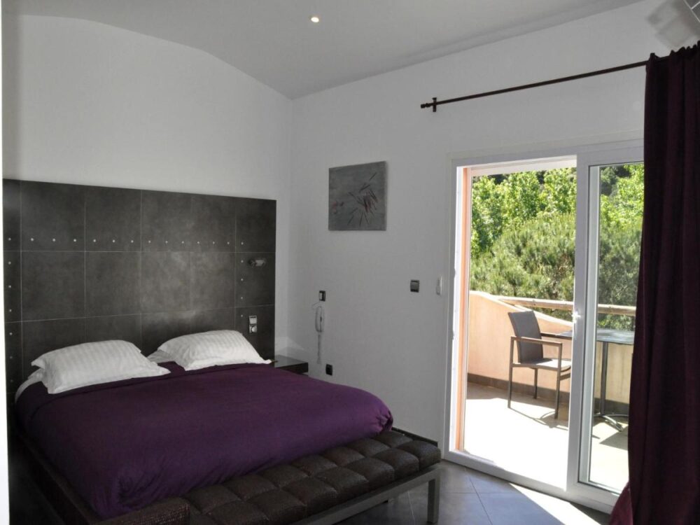 Chambre avec lit double et balcon.