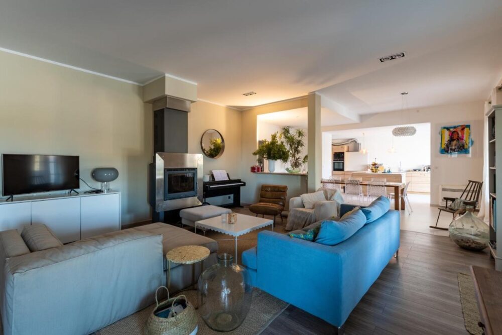 Salon moderne avec canapé bleu et cheminée.