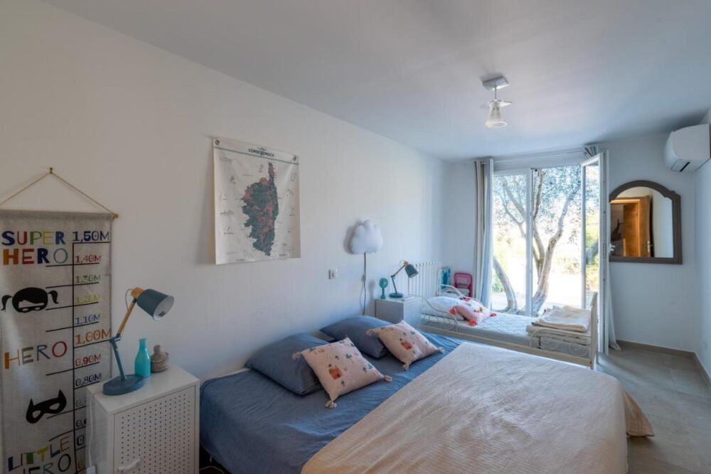 Chambre lumineuse avec lit et décorations murales.