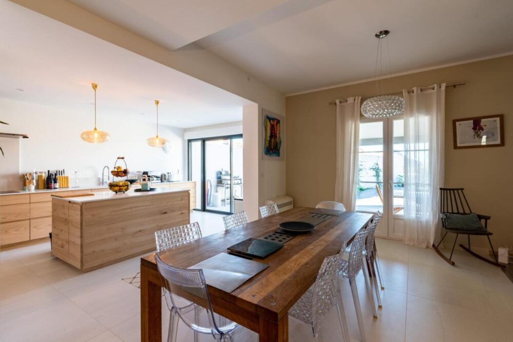 Cuisine moderne avec table en bois, éclairage chaleureux.