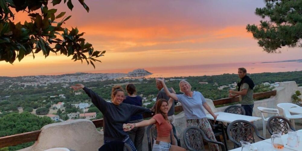 Personnes heureuses devant coucher de soleil panoramique.