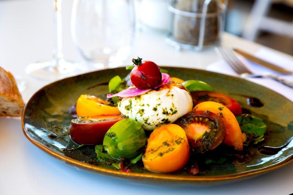 Salade caprese avec tomates colorées et burrata.
