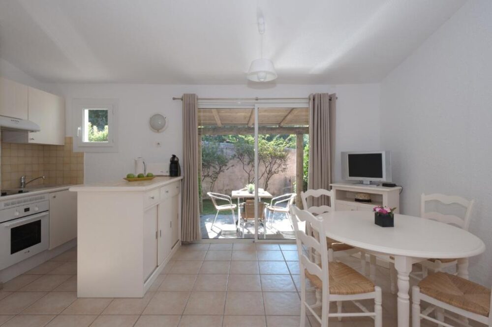 Cuisine moderne avec vue sur terrasse ensoleillée.