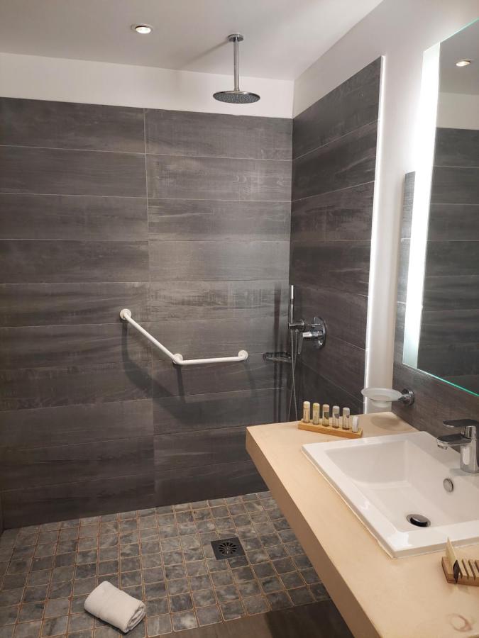 Salle de bain moderne avec douche italienne et lavabo.
