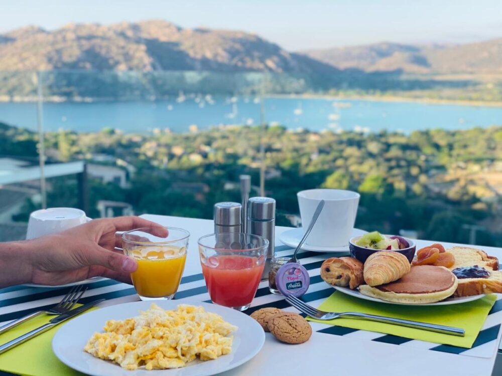 Petit-déjeuner varié avec vue sur lac et montagnes.