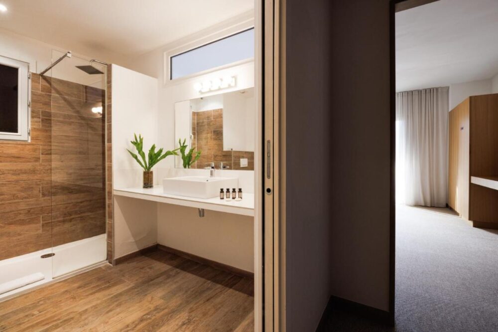 Salle de bain moderne avec douche et lavabo lumineux.
