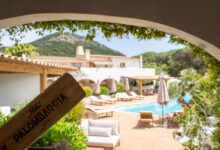 Hôtel avec piscine et terrasse ensoleillée.