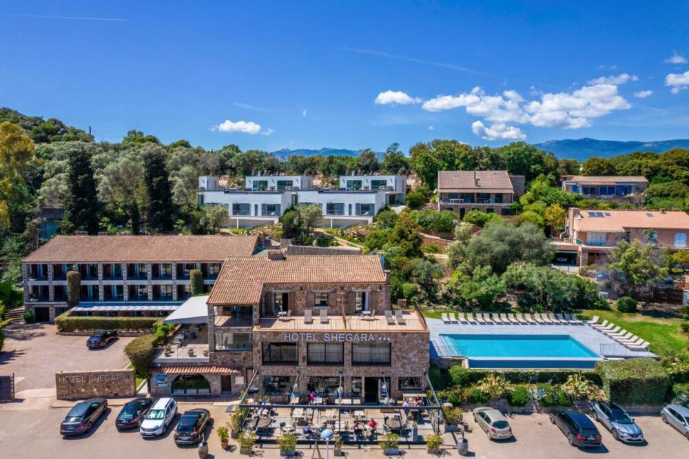 Vue aérienne d'un hôtel avec piscine et jardins.